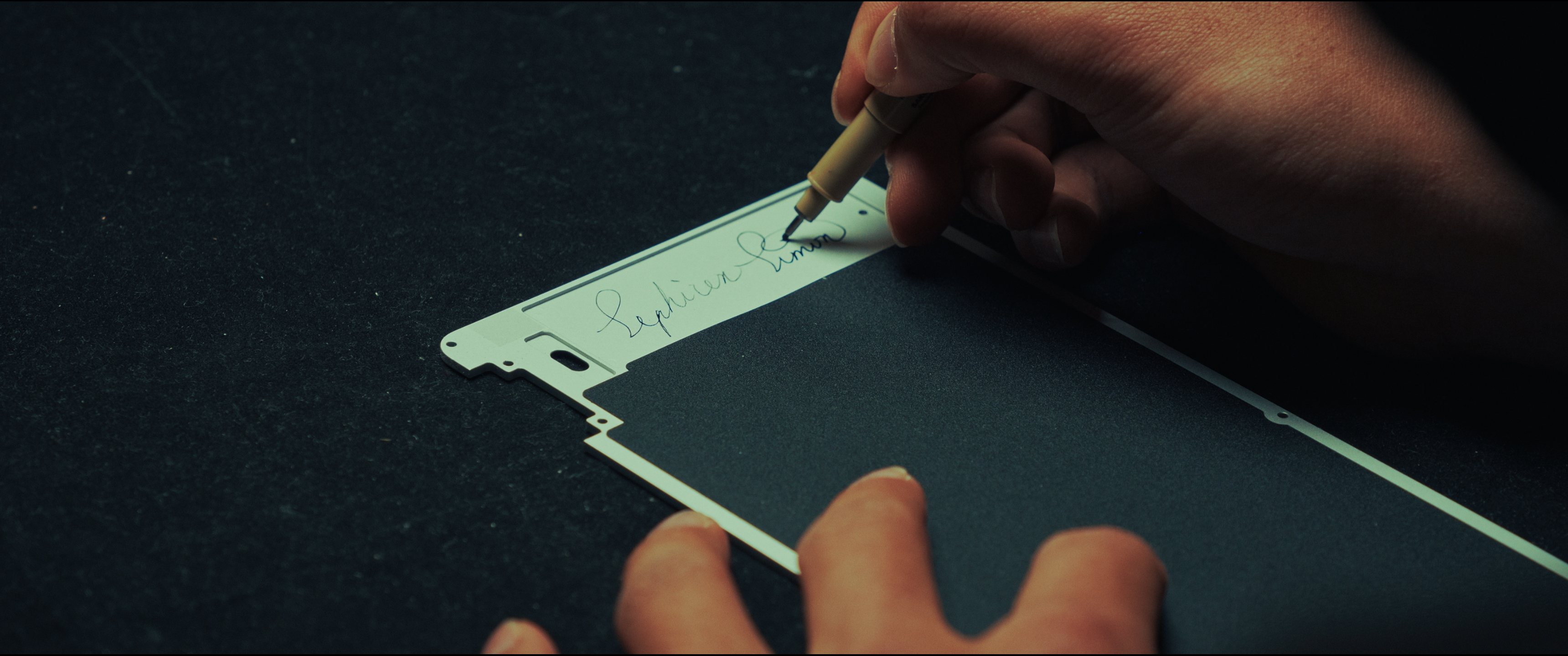 A hand signing the finished keyboard shell